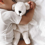 A sleeping baby cuddled up to the Senger Small Cuddly Polarbear