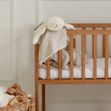 A GOTS organic cotton snowy owl soft toy by Senger available at Babipur hanging over a wooden baby's cot
