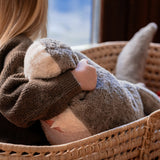 A close up of a child sitting in a basket and holding the Senger Naturwelt Large Cuddly Shark showing the teeth detail on the mouth