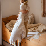 A small child holding the white cuddly Senger XL goose giving an idea of the size of the soft toy