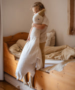 A small child holding the white cuddly Senger XL goose giving an idea of the size of the soft toy