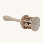 A view of the top of the rattle head, showing the wooden balls inside, on a cream background