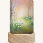 The Snow Drops illustration by Baukje Exler sat in a Toverlux Magic Lantern base.