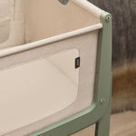 A closeup of the breathable mesh on the sides of the SnuzPod5, showing up-close the beautiful sage green wooden frame.