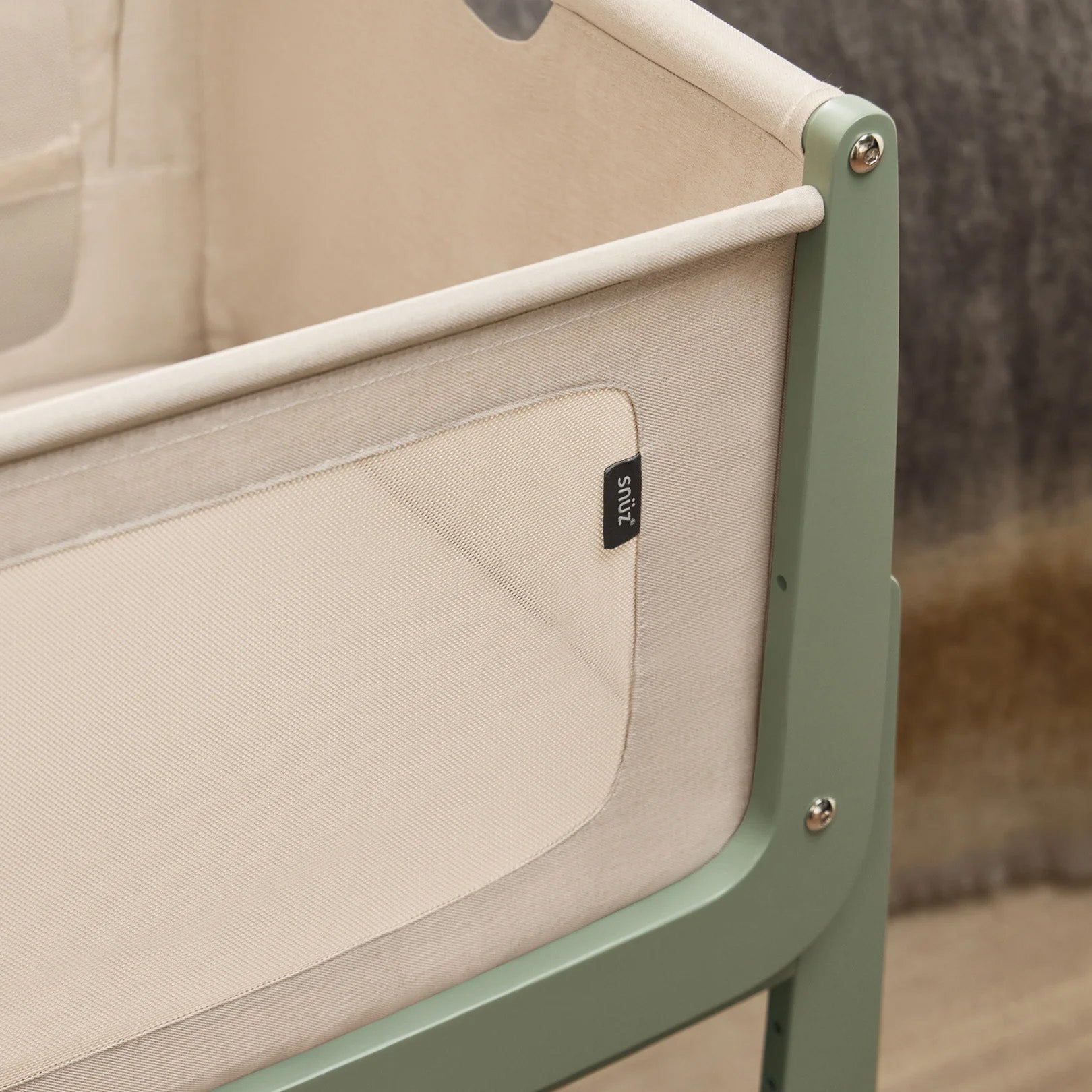 A closeup of the breathable mesh on the sides of the SnuzPod5, showing up-close the beautiful sage green wooden frame.