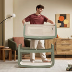 A man detaching the SnuzPod5 bassinet from the main rocking frame, showing how easily portable this baby cot is.