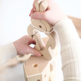 Child clamping a wooden Speelbelovend giant peg on another peg