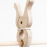Speelbelovend giant wooden peg on wooden frame pole. Peg held by e rubber band for extra grip