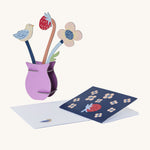 Studio Roof Cardboard Pop Out Card - William Morris Flowers with a card and envelope. The card is navy blue with flowers and a strawberry, and the envelope has a small bird printed on the front. The image is on a cream background