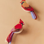 The Studio Roof Cardinals Cardboard Bird Model, on a pale yellow background
