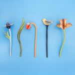 The Studio Roof Cardboard Bouquet - William Morris laid flat in a row on a light blue background
