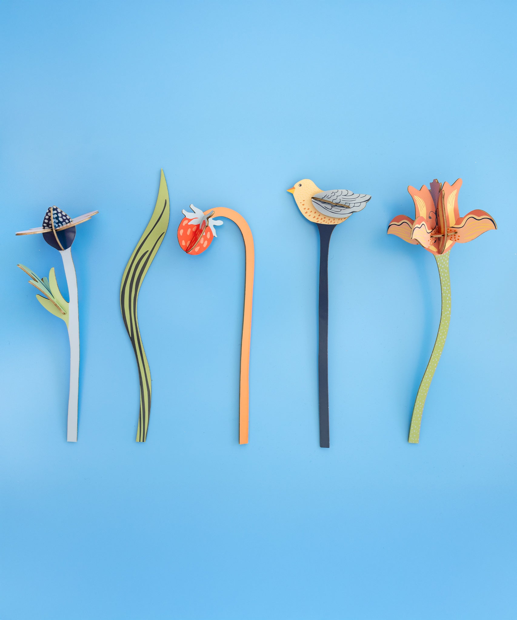 The Studio Roof Cardboard Bouquet - William Morris laid flat in a row on a light blue background