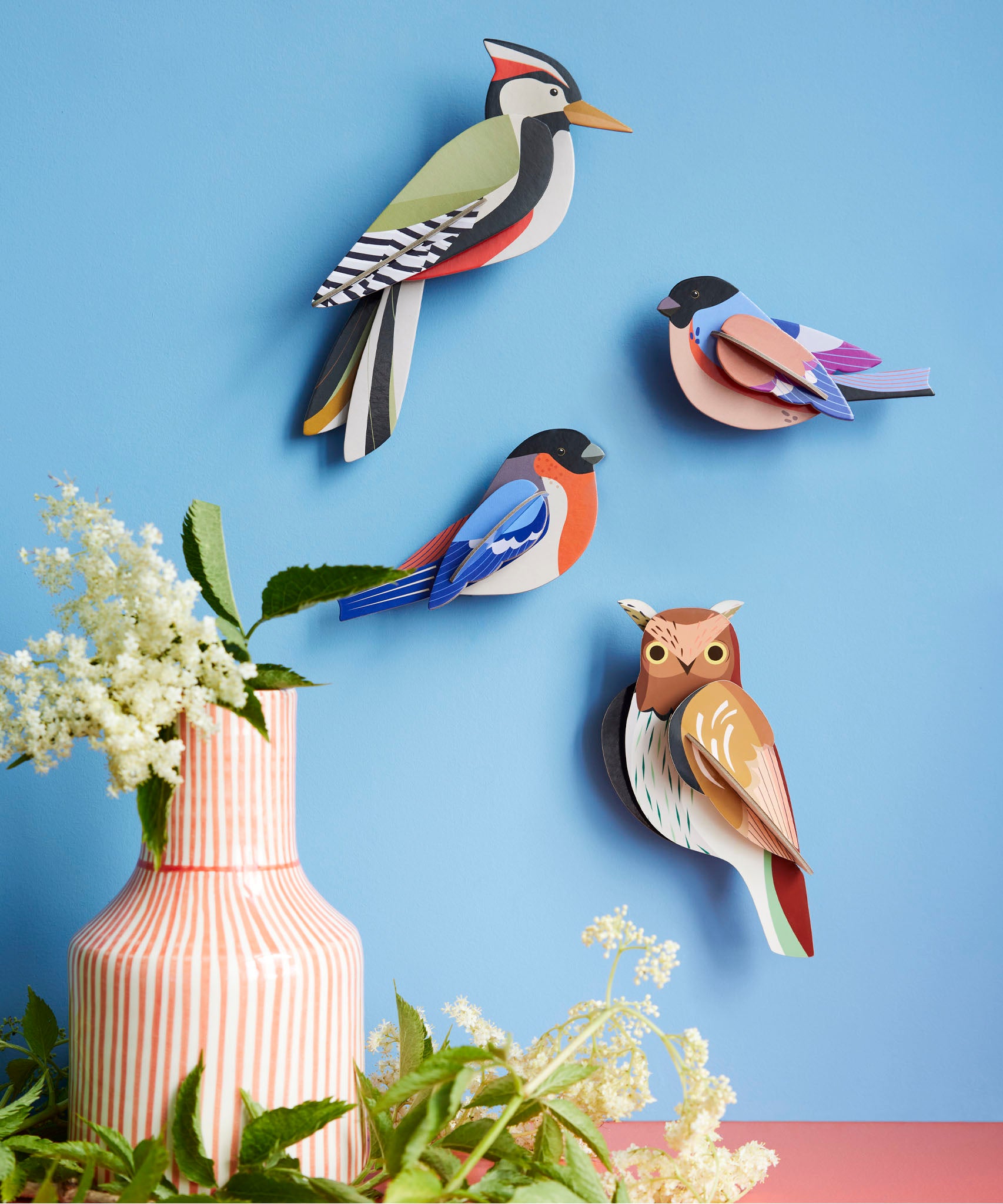 Studio Roof tawny owl wall decoration available at Babipur hanging on a blue wall next to a Studio Roof woodpecker and 2 finches. 