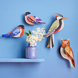 A group of Studio Roof garden birds hanging decorations on a blue wall available at Babipur including the brown tawny owl