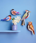 A group of Studio Roof garden birds hanging decorations on a blue wall available at Babipur including the brown tawny owl