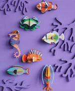 A group of Studio Roof sealife animal wall decorations available at Babipur hanging on a purple coloured wall including a lagoon triggerfish