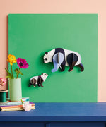 Studio Roof panda family wall decoration available at Babipur hanging on a green board against a lightly coloured wall