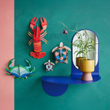 Studio Roof sea turtles wall decorations available at Babipur hanging on a green wall next to a lobster and a crab DIY hanging decoration
