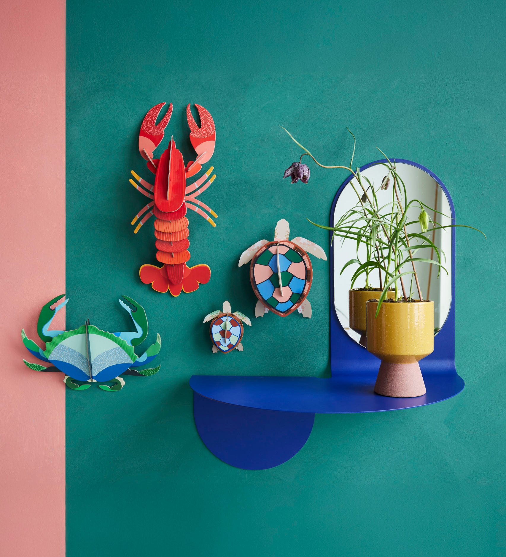 Studio Roof sea turtles wall decorations available at Babipur hanging on a green wall next to a lobster and a crab DIY hanging decoration