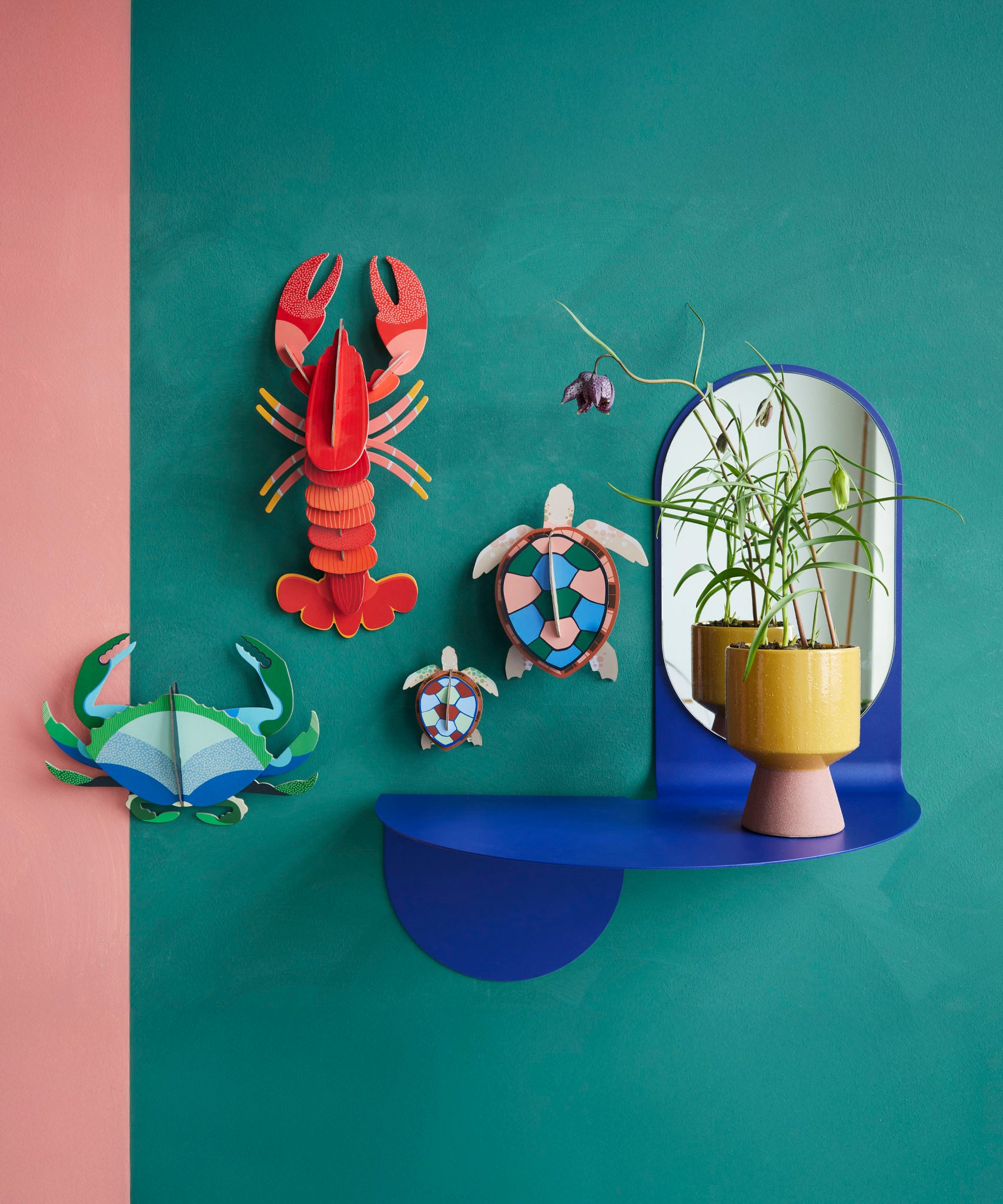 Studio Roof sea turtles wall decorations available at Babipur hanging on a green wall next to a lobster and a crab DIY hanging decoration