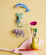 Studio Roof dolphin wall decoration available at Babipur hanging on a yellow wall next to a gecko and elephant DIY hanging decoration