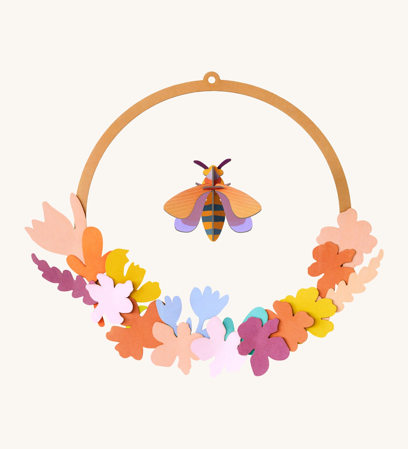 Studio Roof wreath meadow with bee available at Babipur. A DIY kit made from cardboard in a floral wreath design with a bee hanging from the loop.