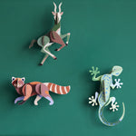 3 Studio Roof 3D Cardboard Models of Wildlife Animals on a green wall - the Antelope, Gecko and the Red Panda.