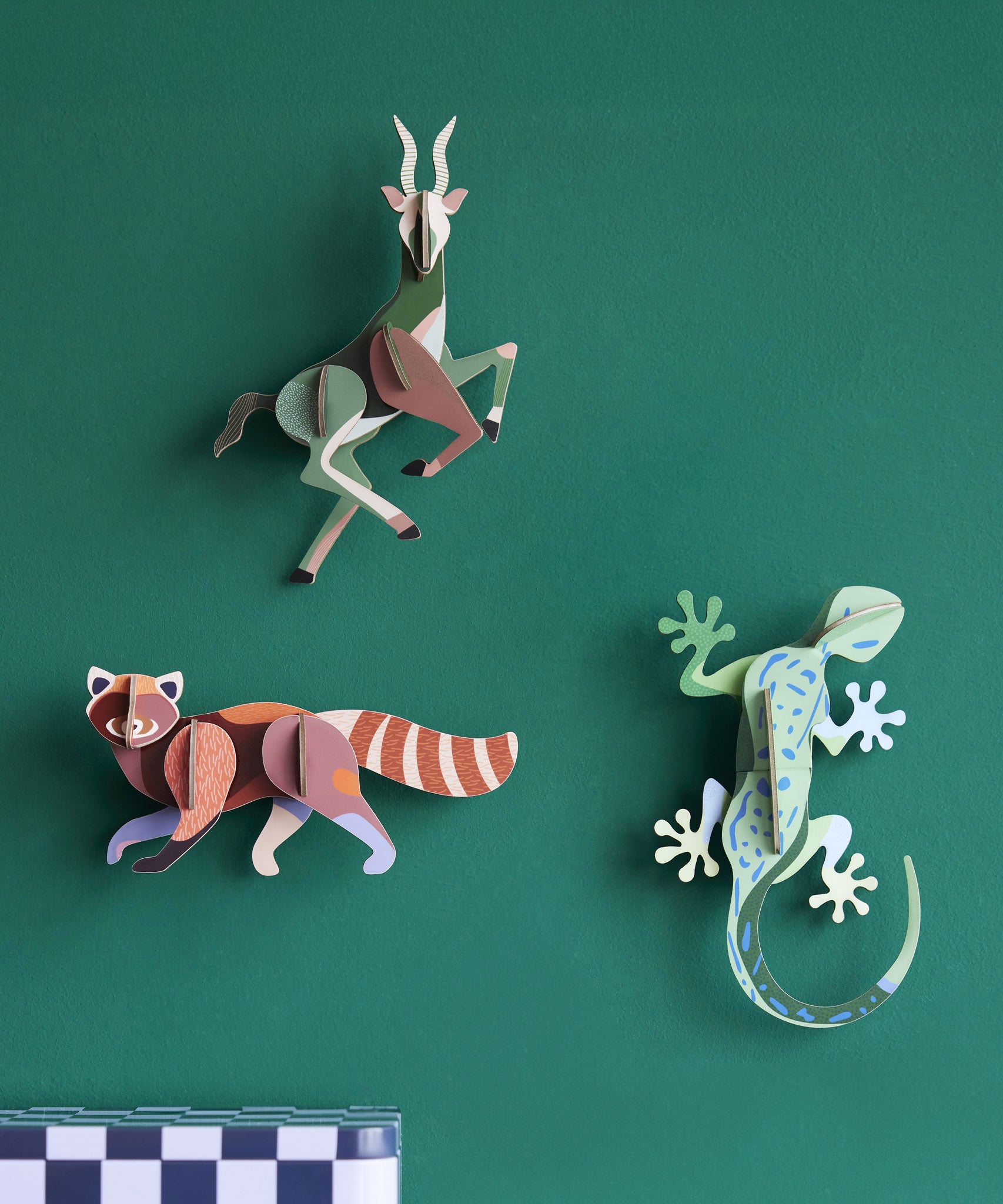3 Studio Roof 3D Cardboard Models of Wildlife Animals on a green wall - the Antelope, Gecko and the Red Panda.