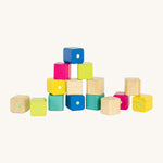 Tegu Baby's First Magnetic Blocks - 15 Piece, in natureal, yellow, pink, green and blue blocks, with some blocks stacked on top of each other on a cream background