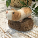 A finished The Makerss - Amiguwoolli Guinea Pig on a wooden table