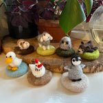 A collection of The Makerss - Amiguwoolli figures which includes a duck, chicken, penguin, bear, owl, sheep and guinea pig