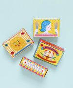 A group of The Printed Peanut sunshine natural handmade soaps showing their decorated packaging box against a blue background.