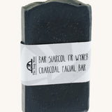 The Soap Mine Charcoal facial bar available at Babipur. A deep slate grey coloured soap bar with a cardboard branding strip.