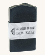 The Soap Mine Charcoal facial bar available at Babipur. A deep slate grey coloured soap bar with a cardboard branding strip.