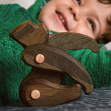 A close up of a Tobe wooden toy gorilla figure available at Babipur posing and showing the grain detail on the toy 