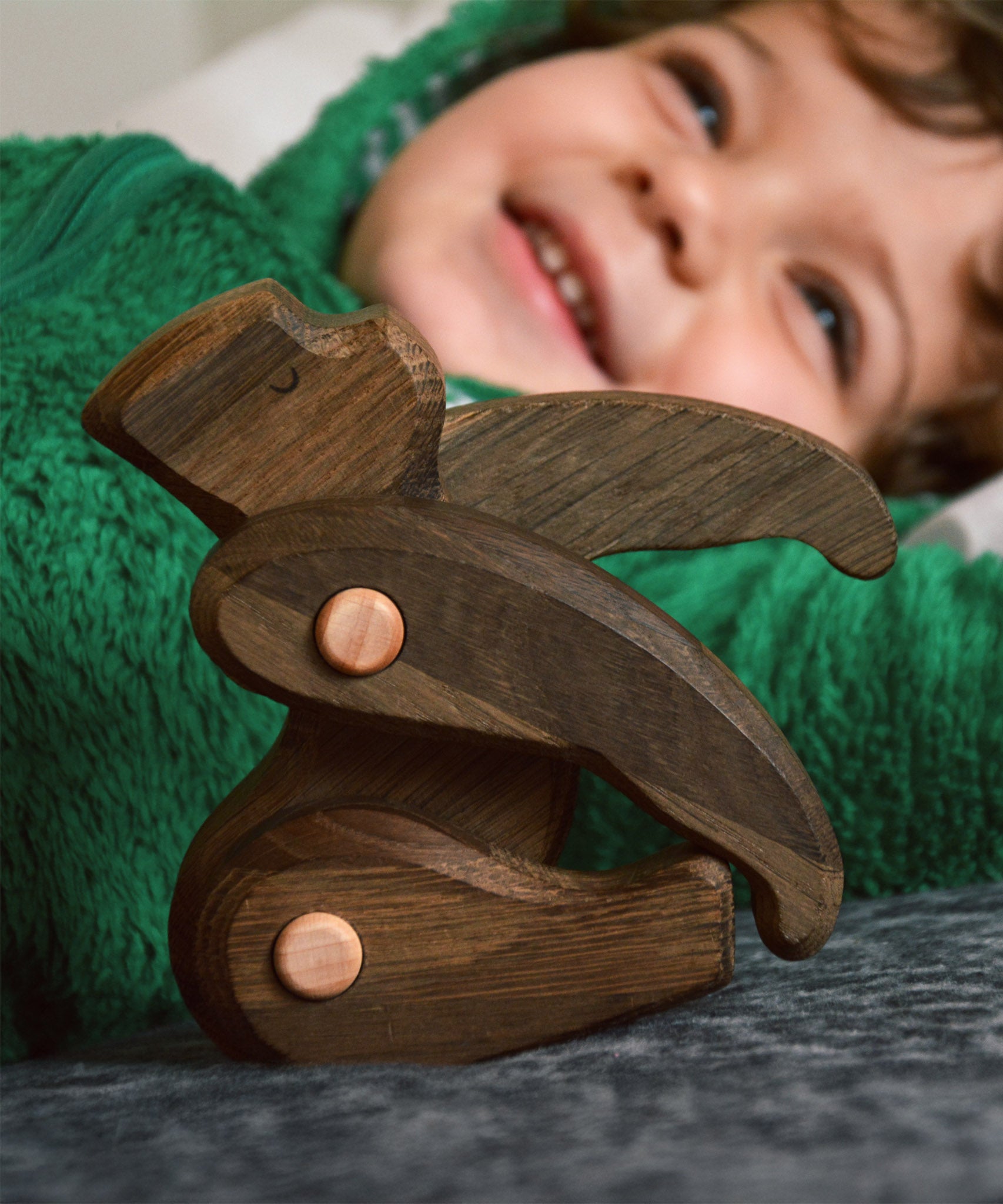 A close up of a Tobe wooden toy gorilla figure available at Babipur posing and showing the grain detail on the toy 