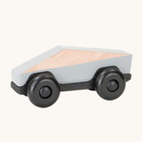 Tobe Poly Car in light grey and black, on a cream background. The car is made from wood in a geometric shape to give a futuristic feel.