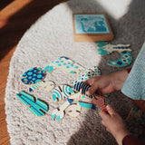 A child assembling some of pieces from the Tobe Pegasus Fantasy Animals wooden Puzzle that's available at Babipur showing the different pieces that come with the set
