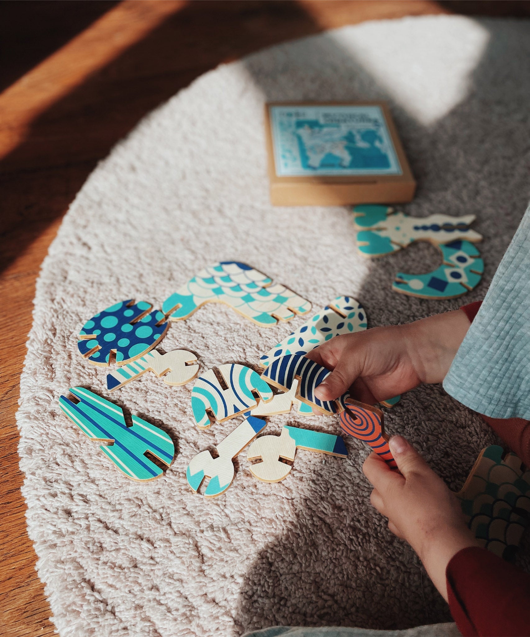 A child assembling some of pieces from the Tobe Pegasus Fantasy Animals wooden Puzzle that's available at Babipur showing the different pieces that come with the set