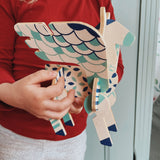 A close up of a child holding a completed Tobe Pegasus Fantasy Animals wooden Puzzle that's available at Babipur showing scale. 