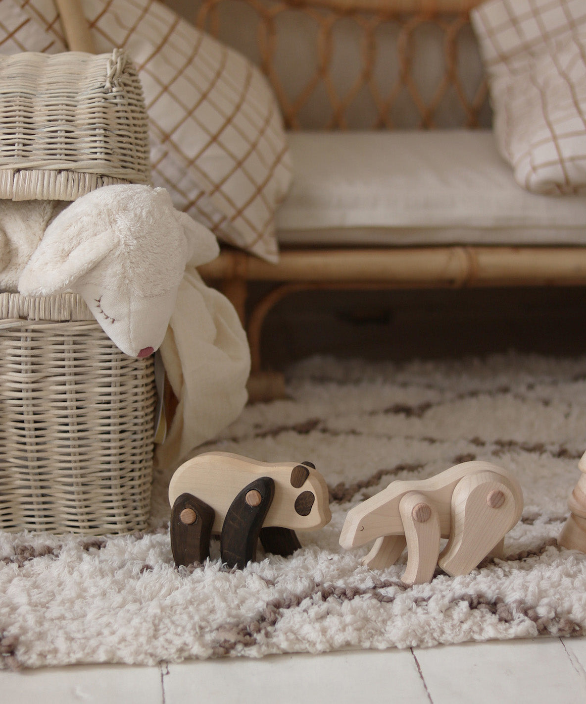 A Tobe Wooden Panda toy standing next to a polar bear on a fluffy rug. These movable animal toys are available at Babipur. 