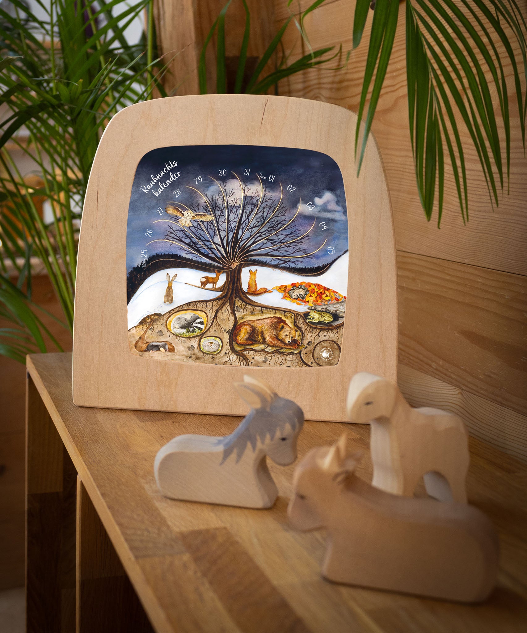 A cosy festive display with the Toverlux 12 holy nights sonne mond und erde silhouette inside a lamp. Silhouette and lamp are available at Babipur.