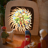 A cosy nativity display with the Toverlux sonne mond und erde nativity advent calendar available at Babipur. Calendar has all of the windows open revealing a lit up silhouette. 