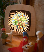 A cosy nativity display with the Toverlux sonne mond und erde nativity advent calendar available at Babipur. Calendar has all of the windows open revealing a lit up silhouette. 