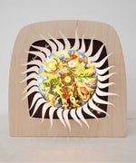 An open Toverlux advent calender sonne mond und erde silhouette available at Babipur.  Displayed in a wooden Toverlux lantern  showing all of the windows open revealing a lit up silhouette 