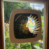A Toverlux sonne mond und erde nativity advent calendar silhouette inside a wooden magic frame available at Babipur. Calendar some of the windows open revealing a lit up silhouette. 
