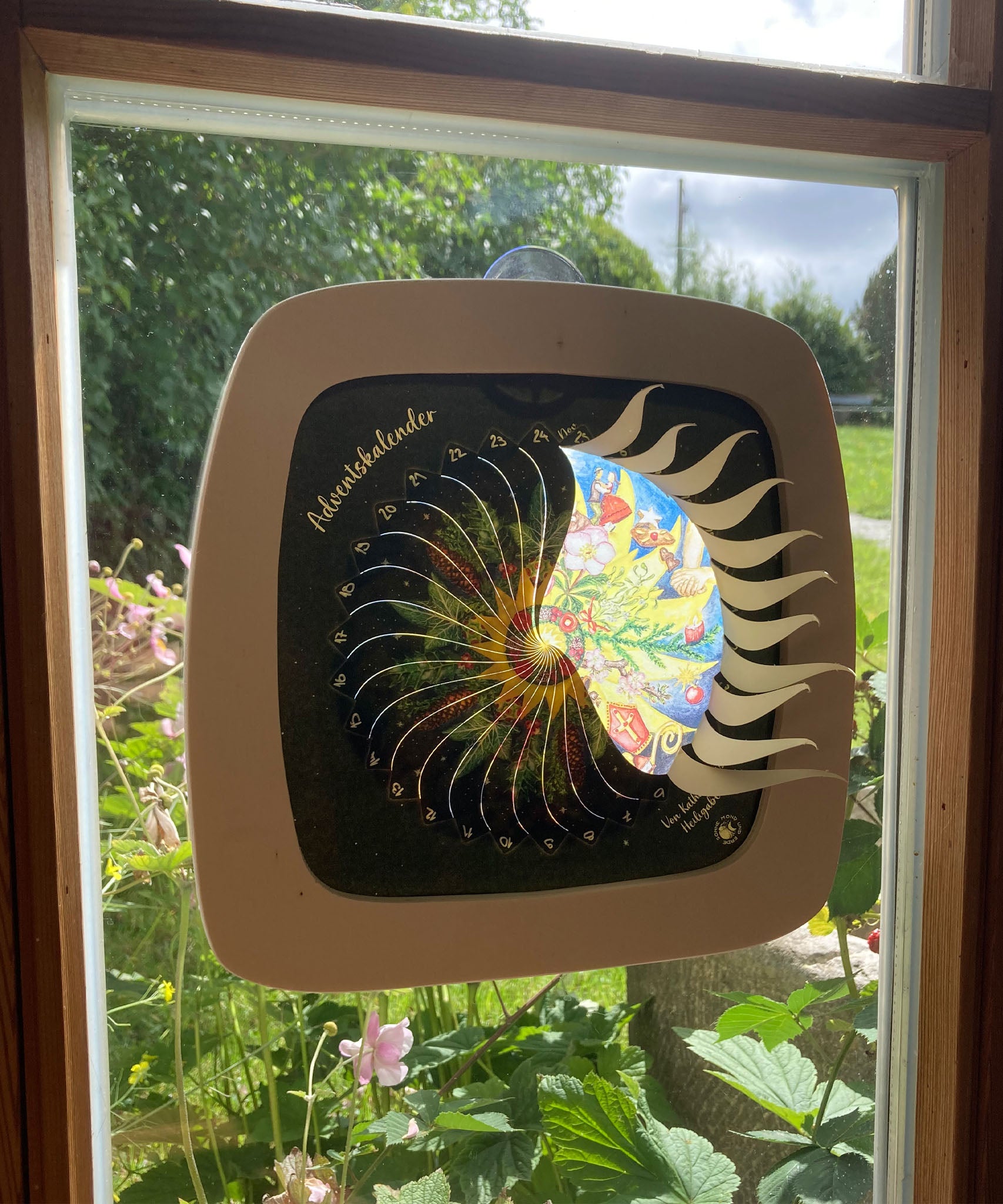 A Toverlux sonne mond und erde nativity advent calendar silhouette inside a wooden magic frame available at Babipur. Calendar some of the windows open revealing a lit up silhouette. 