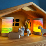Toverlux personalised lantern shades, decorated with watercolours, in a nativity setting with Ostheimer figures and a barn.
