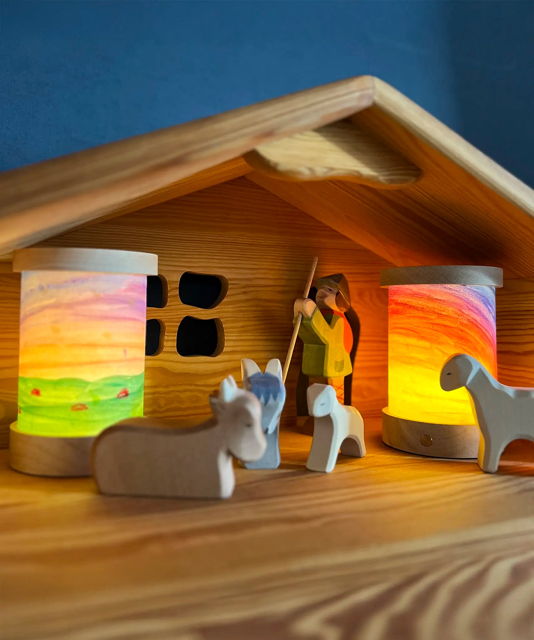 Toverlux personalised lantern shades, decorated with watercolours, in a nativity setting with Ostheimer figures and a barn.