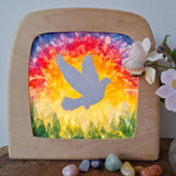 Toverlux DIY Transparencies with a white dove and Spring sky artwork shown in a wooden magic window frame.